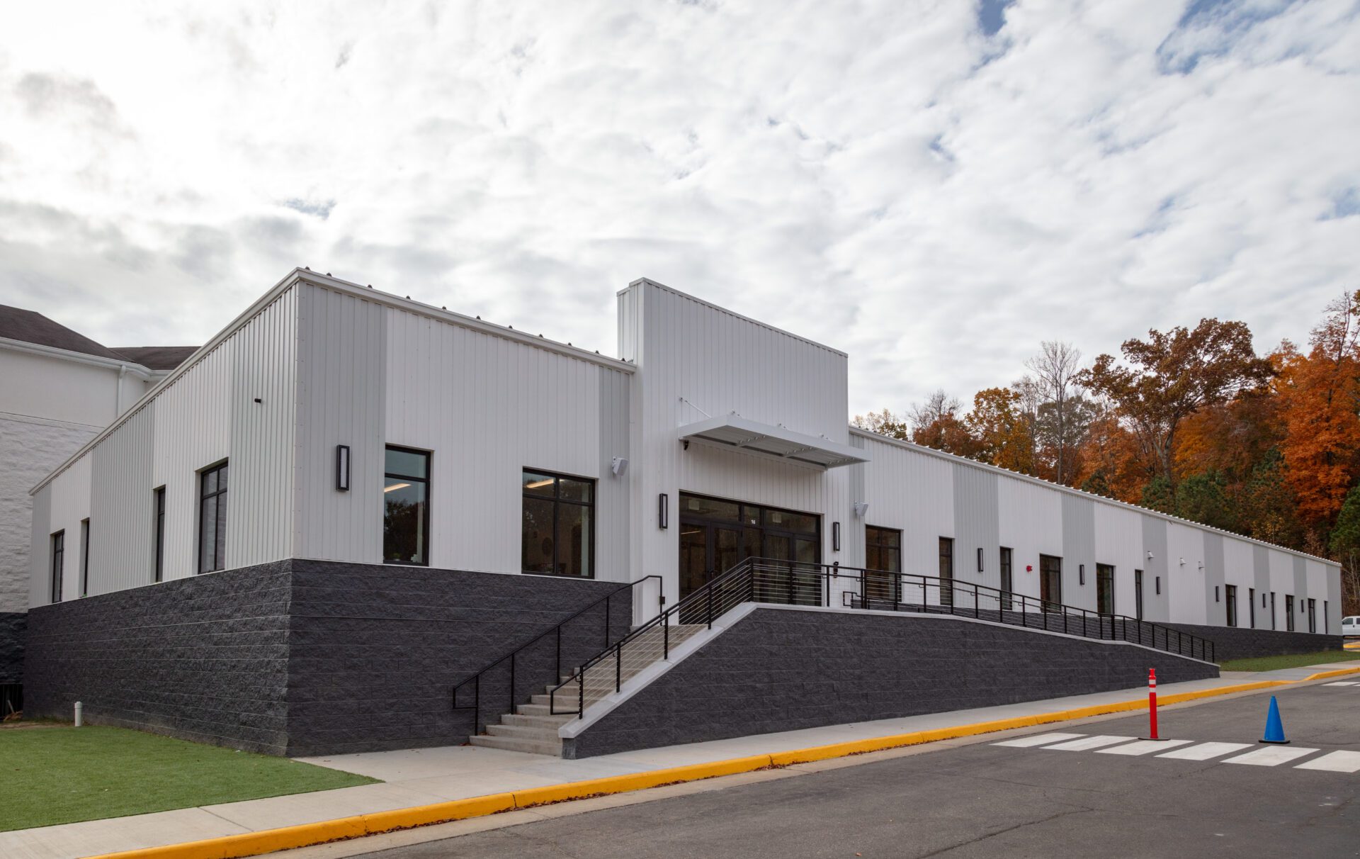 Aerial view of a modern suburban building with gray roofing and stone accents, surrounded by a parking lot